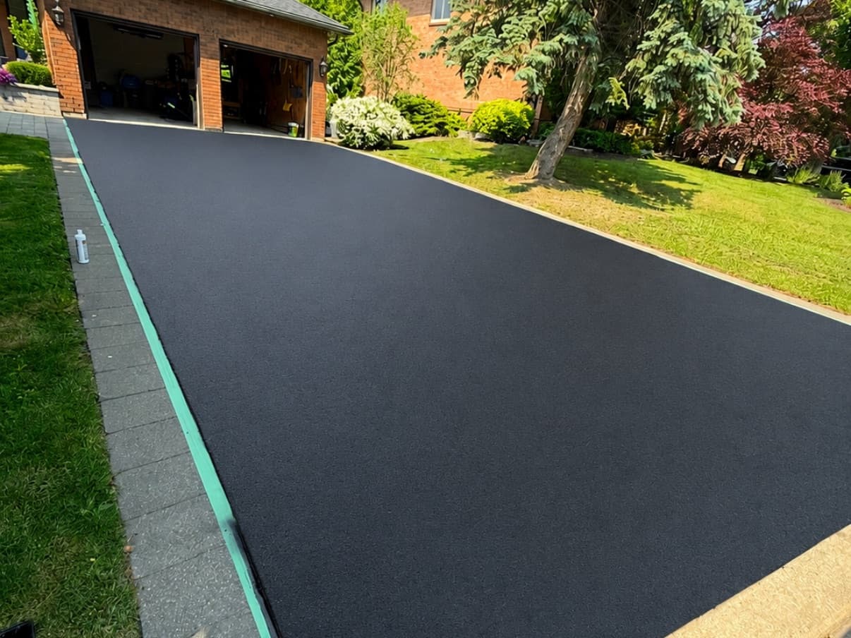 After: Long driveway resealed to a deep, even black